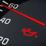 Czerwona, migająca kontrolka oleju na desce rozdzielczej. Wskazówka prędkościomierza blisko 60.