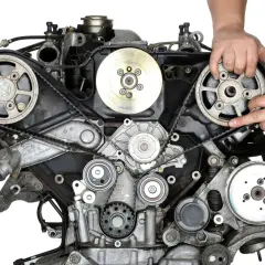 Mechanik sprawdza stan paska rozrządu w samochodzie, który jest kluczowym elementem silnika.