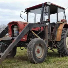 Czerwony Ursus C-360 z ładowaczem. Zastanawiasz się, ile waży Ursus C-360? Ten model to solidna maszyna rolnicza.
