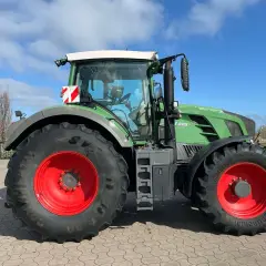 Zielony traktor Fendt 828 V z czerwonymi felgami, gotowy do pracy na polu.