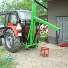 Pomysł na to, jak zrobić ładowacz na tył ciągnika. Zielona konstrukcja zamontowana na pomarańczowym traktorze.