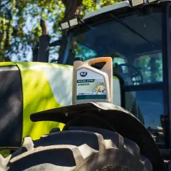 Kanister oleju K2 AGROTECH 10W-30 UTTO na błotniku zielonego traktora.