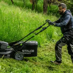 Mężczyzna z kosiarką elektryczną STALCO PERFECT. Zastanawiasz się, jaką kosiarkę traktorek kupić? Forum podpowie!