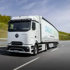 Biały elektryczny ciągnik siodłowy eActros jedzie po autostradzie. Zastanawiasz się, ile waży ciągnik siodłowy? Ten model jest gotowy na przyszłość transportu.