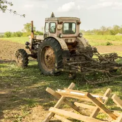 Stary traktor z pługiem na polu. Warto wiedzieć, jak przerejestrować ciągnik po śmierci właściciela, by móc dalej pracować.