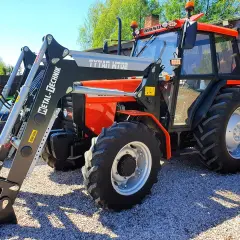Pomarańczowy Ursus 4514 z ładowaczem czołowym Metal-Technik. Dane techniczne tego modelu są imponujące.