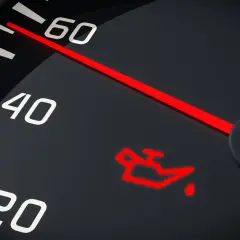 Czerwona, migająca kontrolka oleju na desce rozdzielczej. Wskazówka prędkościomierza blisko 60.