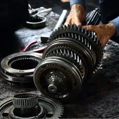 Mechanik składa elementy skrzyni biegów. Zastanawiasz się, ile kosztuje wymiana skrzyni biegów?