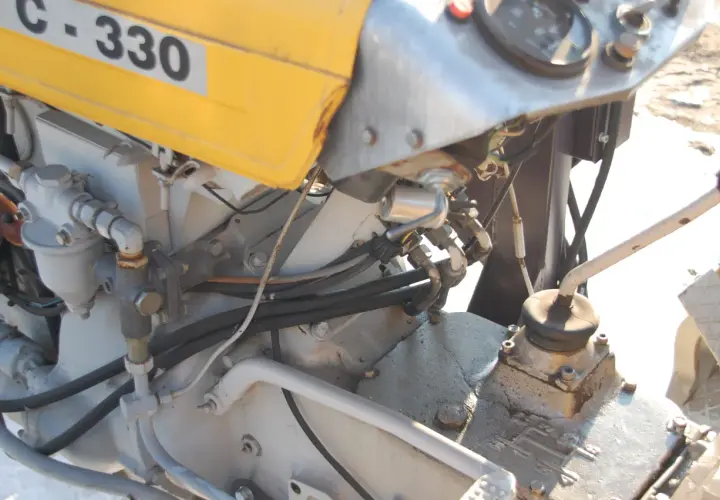 C-330 z wspomaganiem elektrycznym. Widoczny fragment silnika, przewody hydrauliczne i dźwignia zmiany biegów.