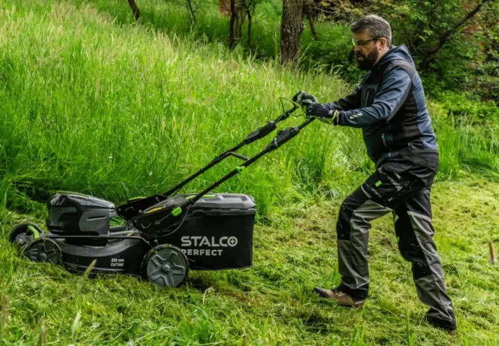 Mężczyzna z kosiarką elektryczną STALCO PERFECT. Zastanawiasz się, jaką kosiarkę traktorek kupić? Forum podpowie!