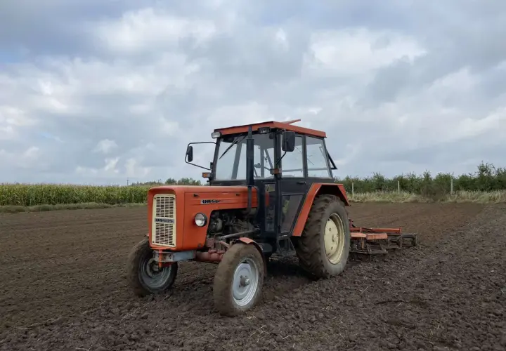 Pomarańczowy Ursus C-360 na polu, gotowy do pracy. Zastanawiasz się, ile oleju do silnika C-360 potrzebujesz?