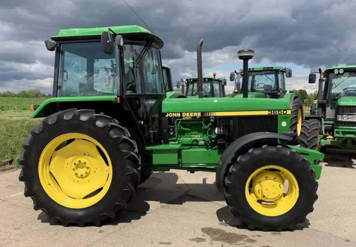 Zielony John Deere 3650 z żółtymi felgami, gotowy do pracy na polu.