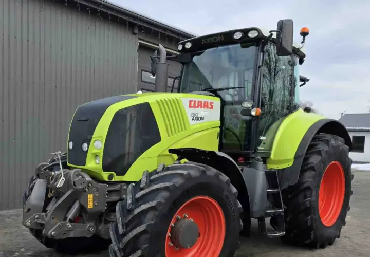 Ciągnik Claas Axion 810 w kolorze limonkowym, gotowy do pracy na polu.
