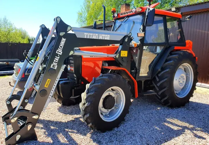 Pomarańczowy Ursus 4514 z ładowaczem czołowym Metal-Technik. Dane techniczne tego modelu są imponujące.