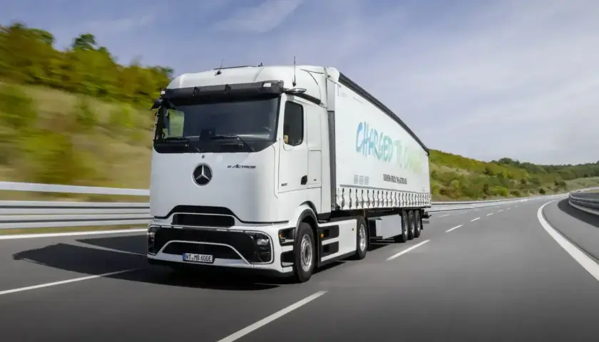 Biały elektryczny ciągnik siodłowy eActros jedzie po autostradzie. Zastanawiasz się, ile waży ciągnik siodłowy? Ten model jest gotowy na przyszłość transportu.