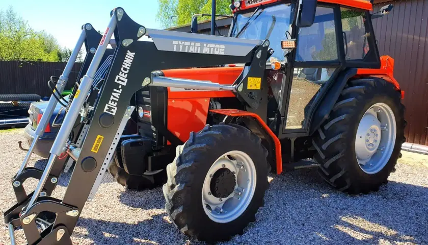 Pomarańczowy Ursus 4514 z ładowaczem czołowym Metal-Technik. Dane techniczne tego modelu są imponujące.