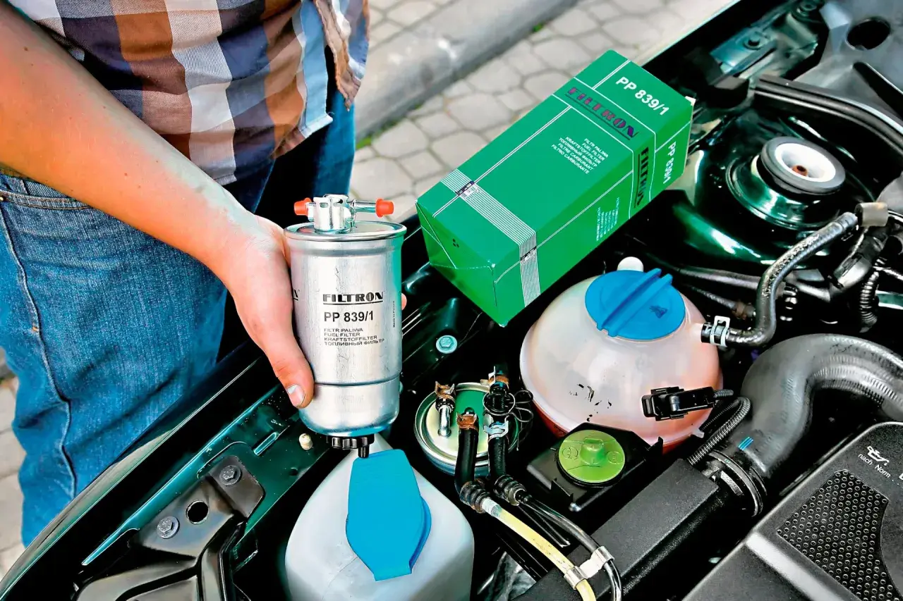 Wymiana filtra paliwa co ile? Nowy filtr paliwa Filtron PP 839/1 w rękach mechanika, obok silnika.