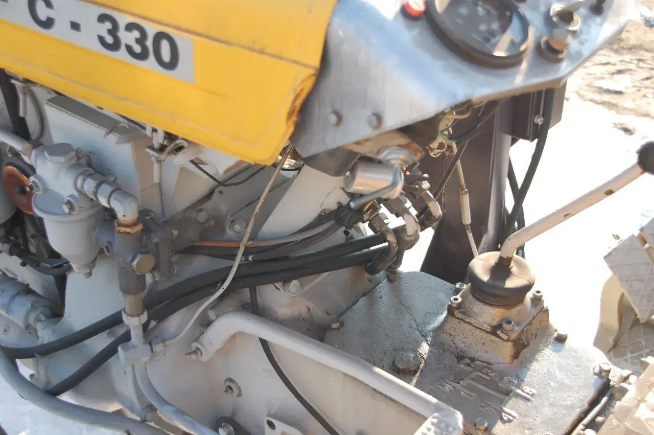 C-330 z wspomaganiem elektrycznym. Widoczny fragment silnika, przewody hydrauliczne i dźwignia zmiany biegów.