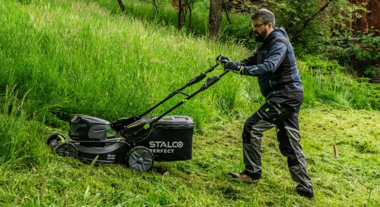 Mężczyzna z kosiarką elektryczną STALCO PERFECT. Zastanawiasz się, jaką kosiarkę traktorek kupić? Forum podpowie!