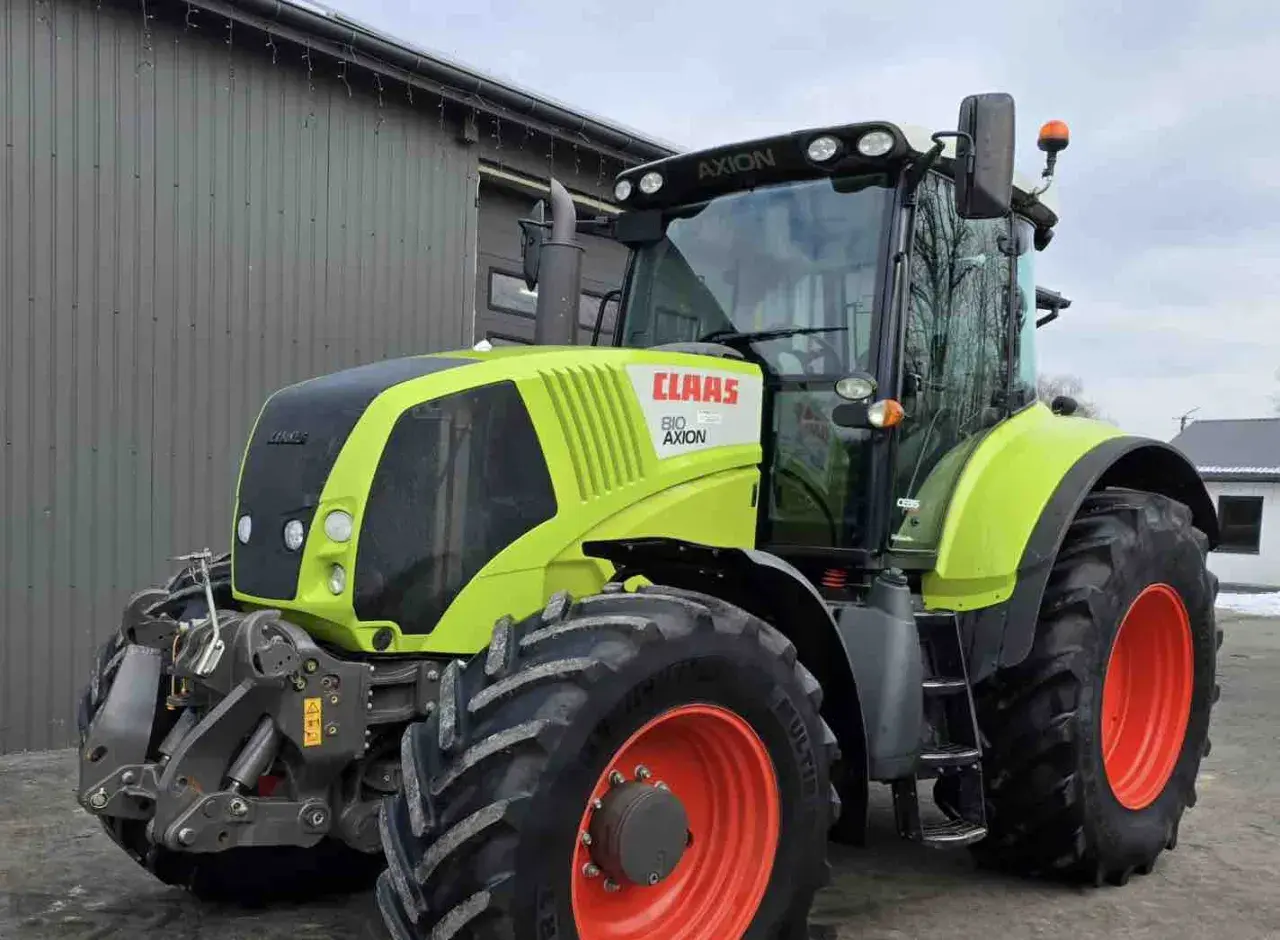 Ciągnik Claas Axion 810 w kolorze limonkowym, gotowy do pracy na polu.