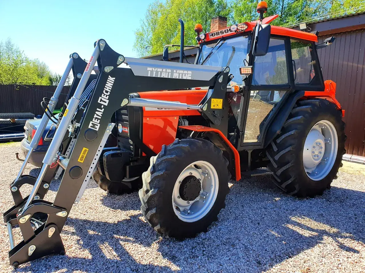 Pomarańczowy Ursus 4514 z ładowaczem czołowym Metal-Technik. Dane techniczne tego modelu są imponujące.