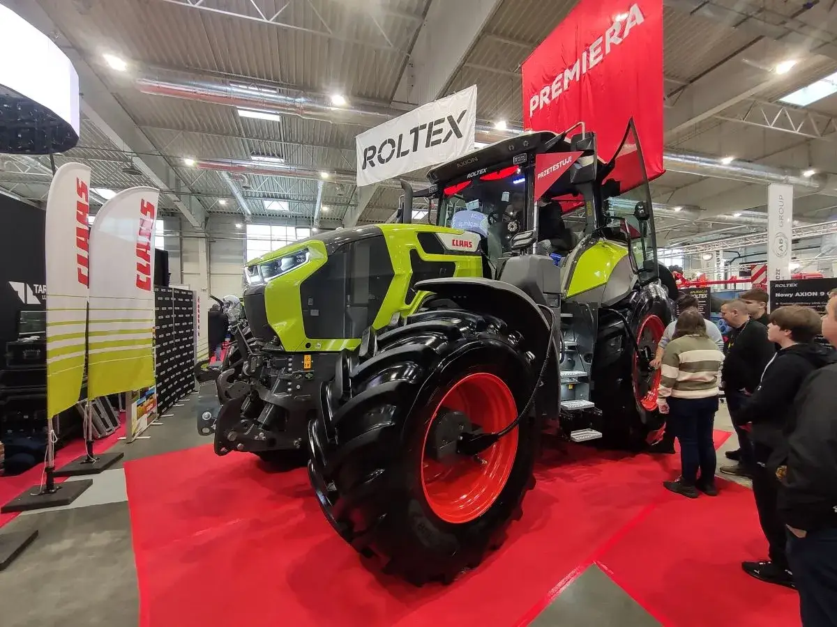 Nowy Claas Axion 810 na targach, prezentowany na czerwonym dywanie.