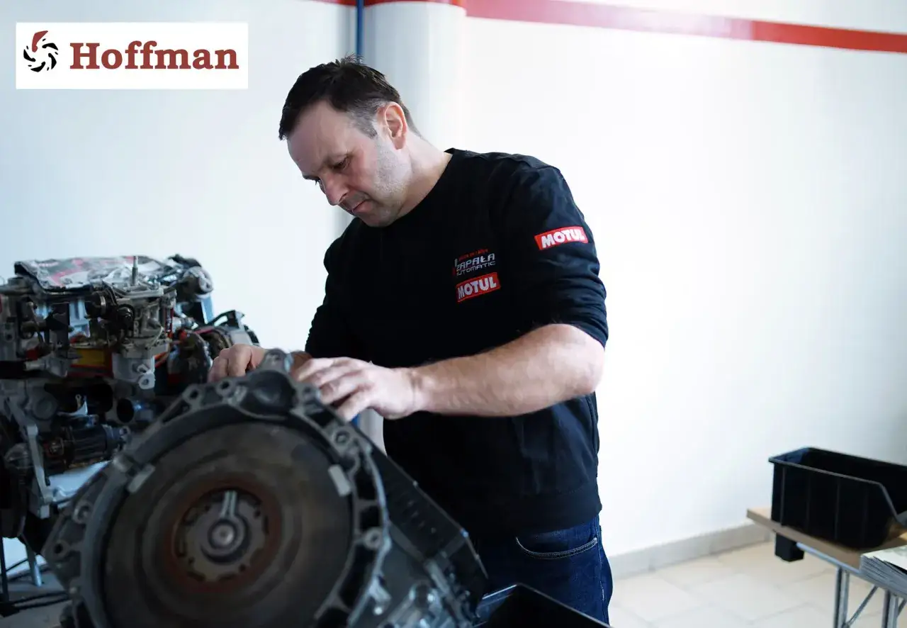Mechanik pracuje nad adaptacją skrzyni biegów w warsztacie.