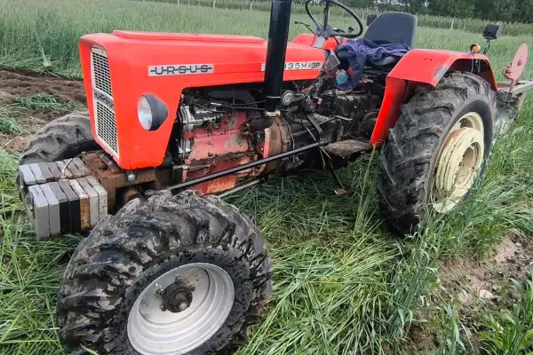 Czerwony Ursus 335M-3P, z doczepionymi obciążnikami, gotowy do pracy w polu. Ten wierny ciapek to symbol polskiego rolnictwa.